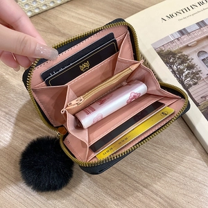 Black quilted mini wallet with pompom keychain and multi-layer organizer for cards