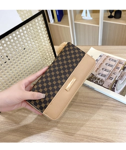 Detail of a dual-tone long zip wallet featuring clover pattern and gold metal accent