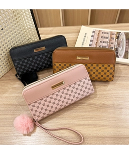 Detail of long floral print wallets with gold metal zippers and soft pompom charms