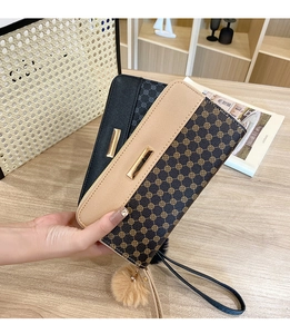 Detail of long wallets showing retro floral patterns and quilted leather with pompom charm