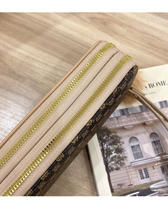 Detail of double zipper long wallet with vintage monogram pattern and wristlet strap