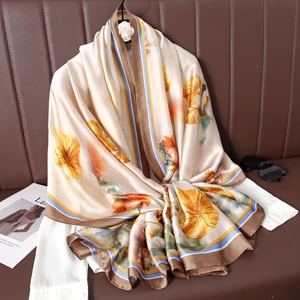 Écharpe en soie aux motifs floraux artistiques beige et orange, drapée sur une chemise chic