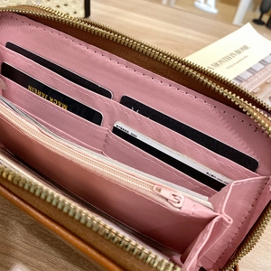 Long leather wallet for women with zipper and multiple card slots on wooden table
