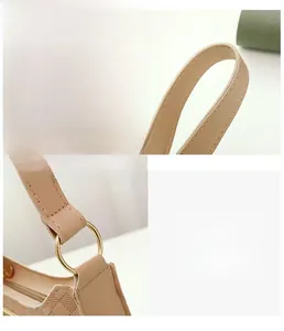 Detailed view of woven texture, golden ring hardware and stitching on beige shoulder bag