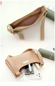 Detail view of woven checkerboard texture and interior capacity of the beige underarm bag