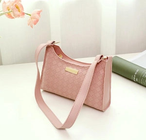 Detail of pink checkerboard textured underarm bag with gold metal clasp and strap