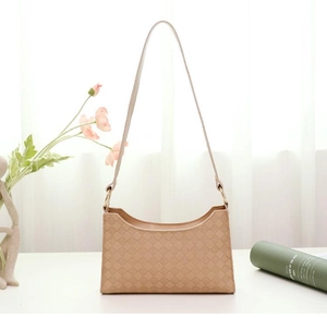Close-up of apricot shoulder bag with quilted diamond pattern and elegant leather strap