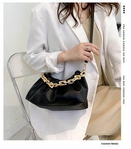 Détail du sac nuage plissé noir avec grosse chaîne dorée et texture en cuir mat de luxe