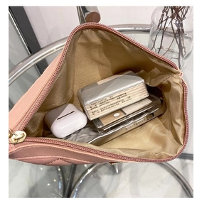 Détail de l'intérieur d'une pochette rose matelassée avec fermeture éclair dorée chic