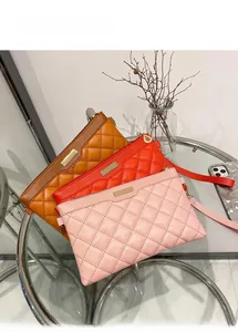 Détail de pochettes en similicuir matelassé avec plaques en métal marron, orange et rose