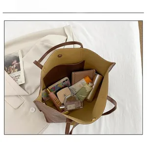 Sac fourre-tout en cuir litchi marron montrant sa grande capacité et son fermoir