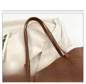 Vue détaillée de la bandoulière en cuir marron foncé avec texture naturelle grain de litchi