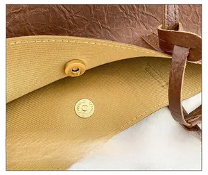 Détail du sac cabas en cuir marron montrant le fermoir magnétique et la doublure beige