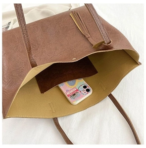 Détail intérieur du sac cabas marron vintage montrant le cuir PU texturé et la poche