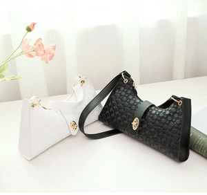 Detail of black and white textured underarm bags with gold oval metal twist locks