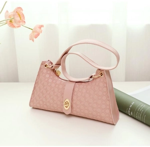 Close-up of pink underarm bag featuring unique circular embossed texture and gold metal clasp