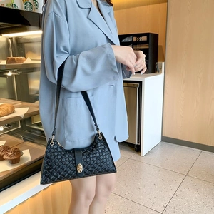 Fashionable black printed underarm bag with metal buckle shown on model in blue blazer