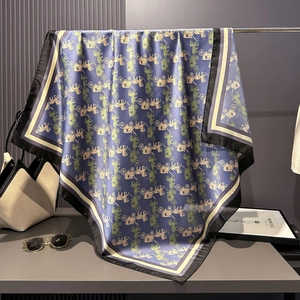 Detailed view of blue silk satin scarf featuring vintage carriage patterns and silk texture