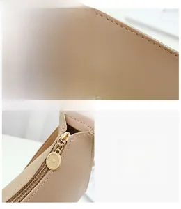 Detail of beige leather shoulder bag showing precise stitching and gold metal zipper puller