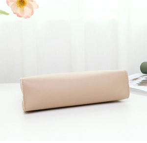 Detailed base view of a minimalist beige leather shoulder bag with fine stitching