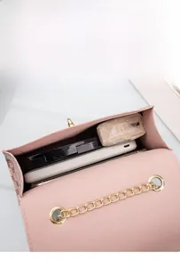 Close-up of pink embossed leather handbag showing spacious interior with chain strap