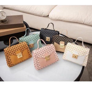 Multiple vintage monogrammed handbags in various colors displayed on a white table