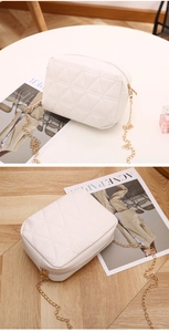 Detail of white quilted crossbody bag with triangle stitching and gold chain strap
