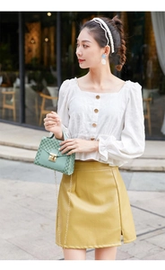 Close-up of mint green patterned crossbody bag with gold chain and metal lock detail