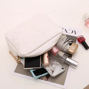 White quilted square bag with gold chain strap showing large internal storage capacity