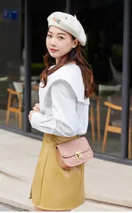 Detail of pink quilted crossbody bag with gold chain strap and metal turn-lock closure