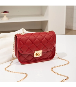 Detail of red quilted PU leather shoulder bag with golden chain and twist lock