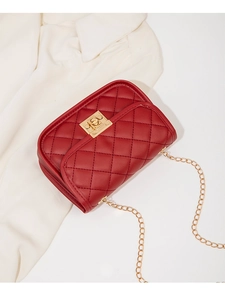 Close-up of red quilted square bag with gold twist lock and elegant chain strap details