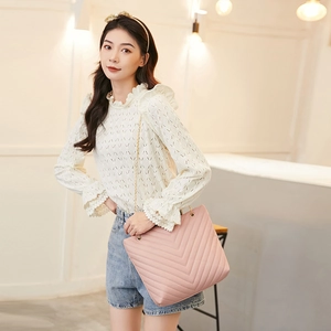 Pink quilted tote bag with V-shaped embroidery and elegant gold chain strap detail