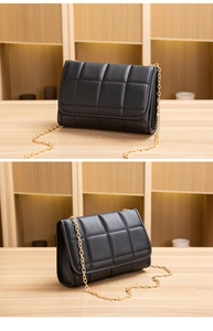 Detail of black quilted leather texture and gold chain strap on a small crossbody bag