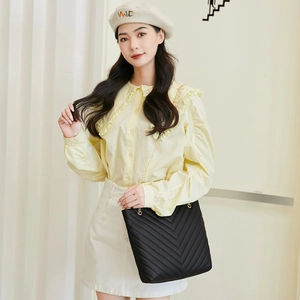 Close-up of black V-quilted faux leather bag with elegant gold chain shoulder strap