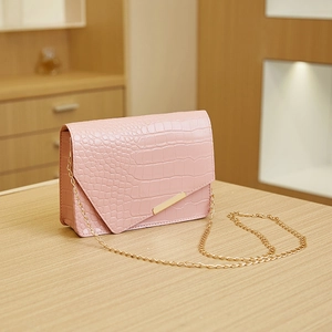 Close-up of pink crocodile pattern mini bag with golden chain and metallic buckle
