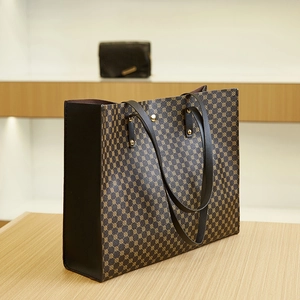 Detail view of large tote bag with brown geometric pattern and black side paneling