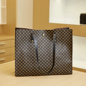 Detail of a large tote bag with gold geometric dots, rivets and a magnetic snap button