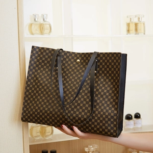 Detail of a large vintage tote bag with geometric patterns and golden buckle closure