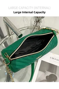 Gros plan du sac cylindrique vert matelassé montrant l'intérieur spacieux et le zip doré