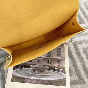 Detail of yellow stone pattern crossbody bag showing suede interior and gold chain strap