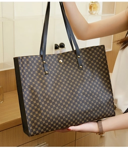 Detail of large tote bag with geometric patterns, long handles, and gold rivet accents