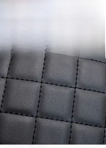 Macro detail of black quilted leather camera bag with precision stitching and padding