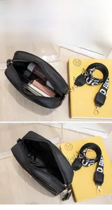 Internal view of black quilted camera bag showing space for phone and cosmetics