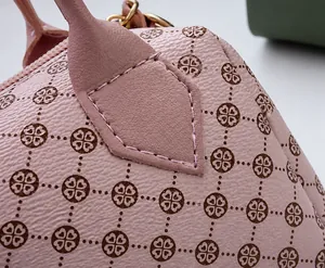 Macro shot of pink lychee leather stitching and clover pattern on a pillow bag
