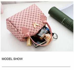 Pink Boston bag with butterfly hardware showing interior storage for lipstick and perfume