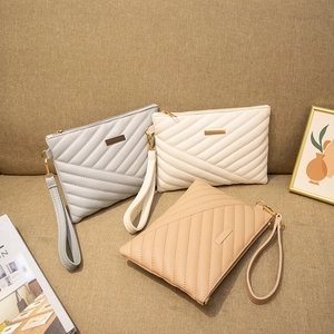 Quilted minimalist envelope clutch bag in blue, white, and khaki with wrist strap