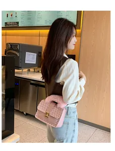 Pink crossbody bag with monogram pattern and soft faux fur handle detail in a street view