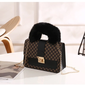 Detail of luxury geometric print handbag with plush faux fur handle and gold chain strap