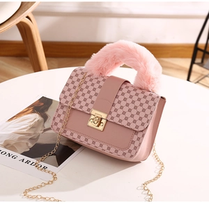 Detail of pink faux leather handbag with geometric patterns and faux fur handle
